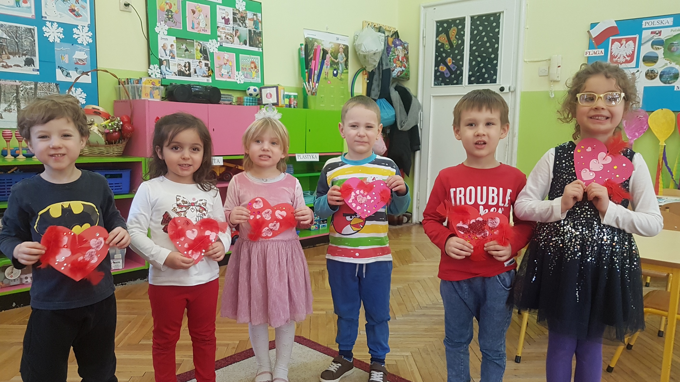 1.Dzieci stoją w szeregu – prezentują wykonane samodzielnie kartki walentynkowe w kształcie serc.